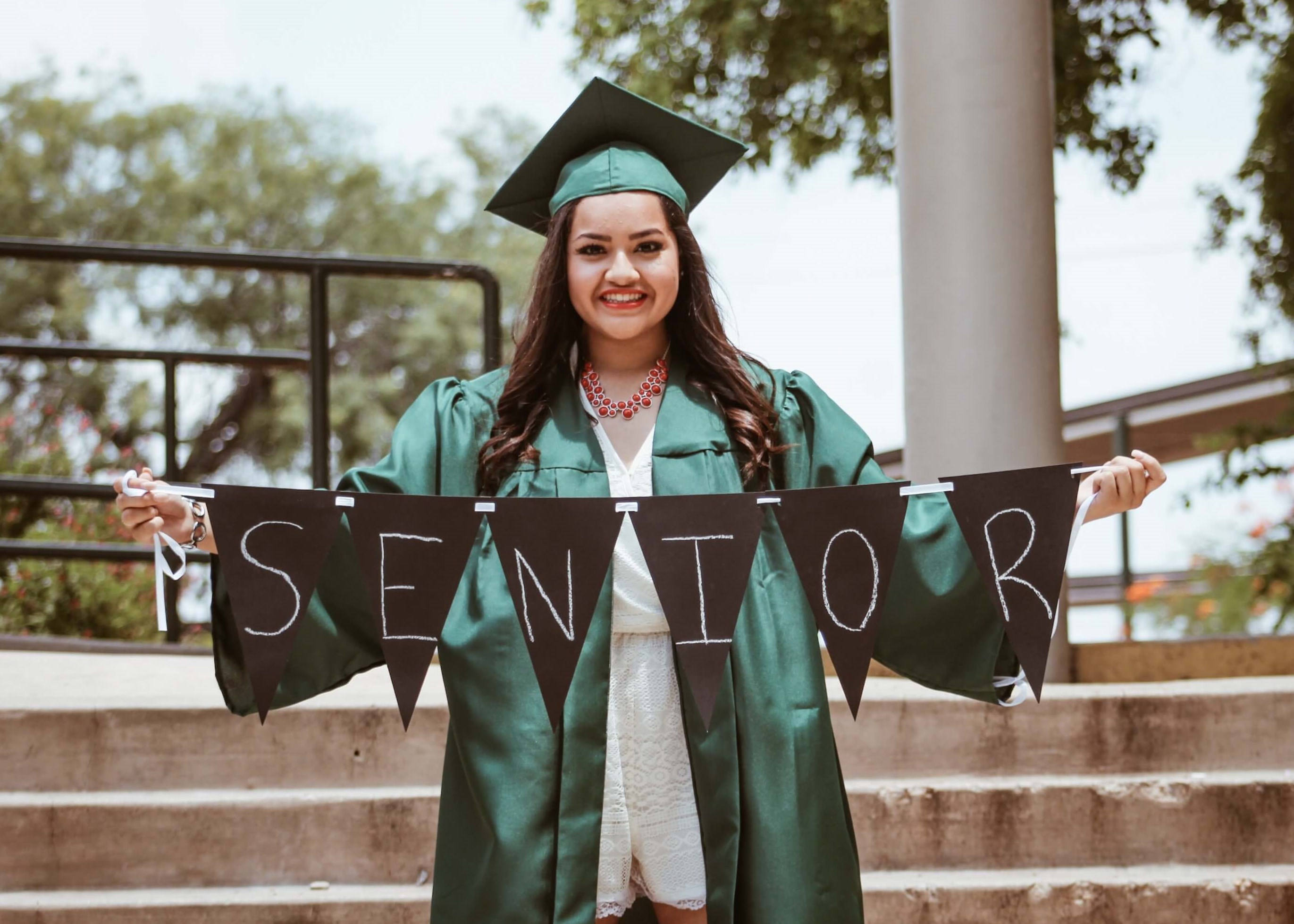 Graduate holding senior sign a